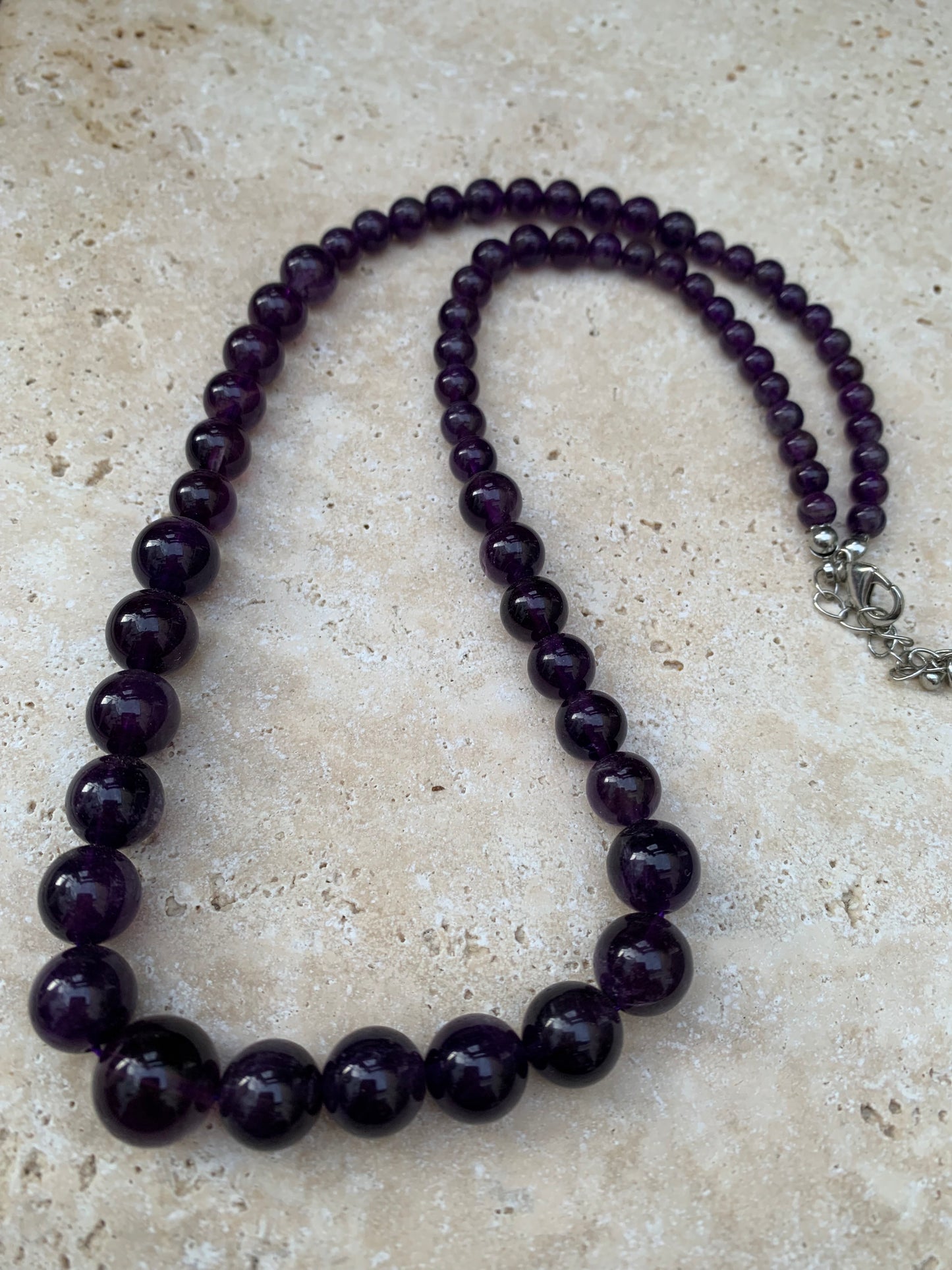 Améthyste – Collier en chute de perles rondes 4 à 10 mm • Longueur 50 cm + 4 cm de chaînette • Fermoir mousqueton. Très belle pièce !