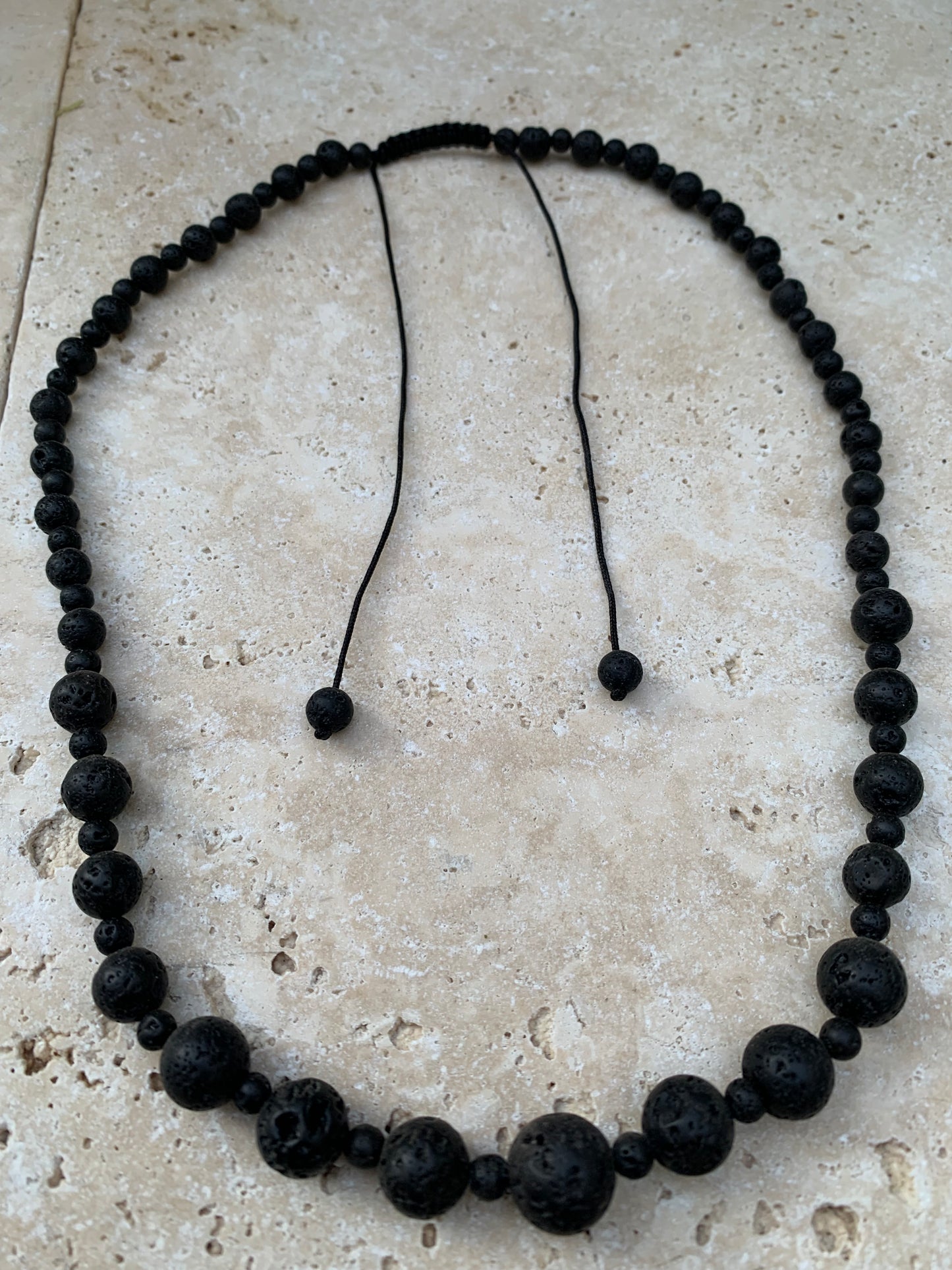 Pierre de lave, 'collier/ chute de perle', de forme ronde de 4 à 10 mm -50 cm. Fermeture coullissante. très belle pièce !