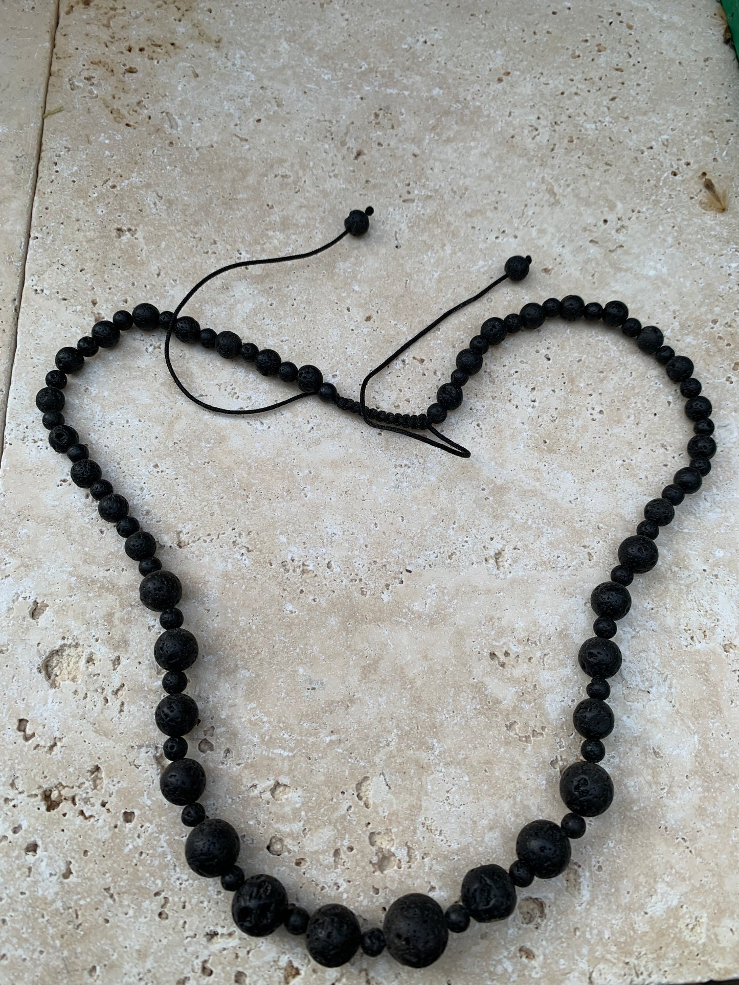 Pierre de lave, 'collier/ chute de perle', de forme ronde de 4 à 10 mm -50 cm. Fermeture coullissante. très belle pièce !