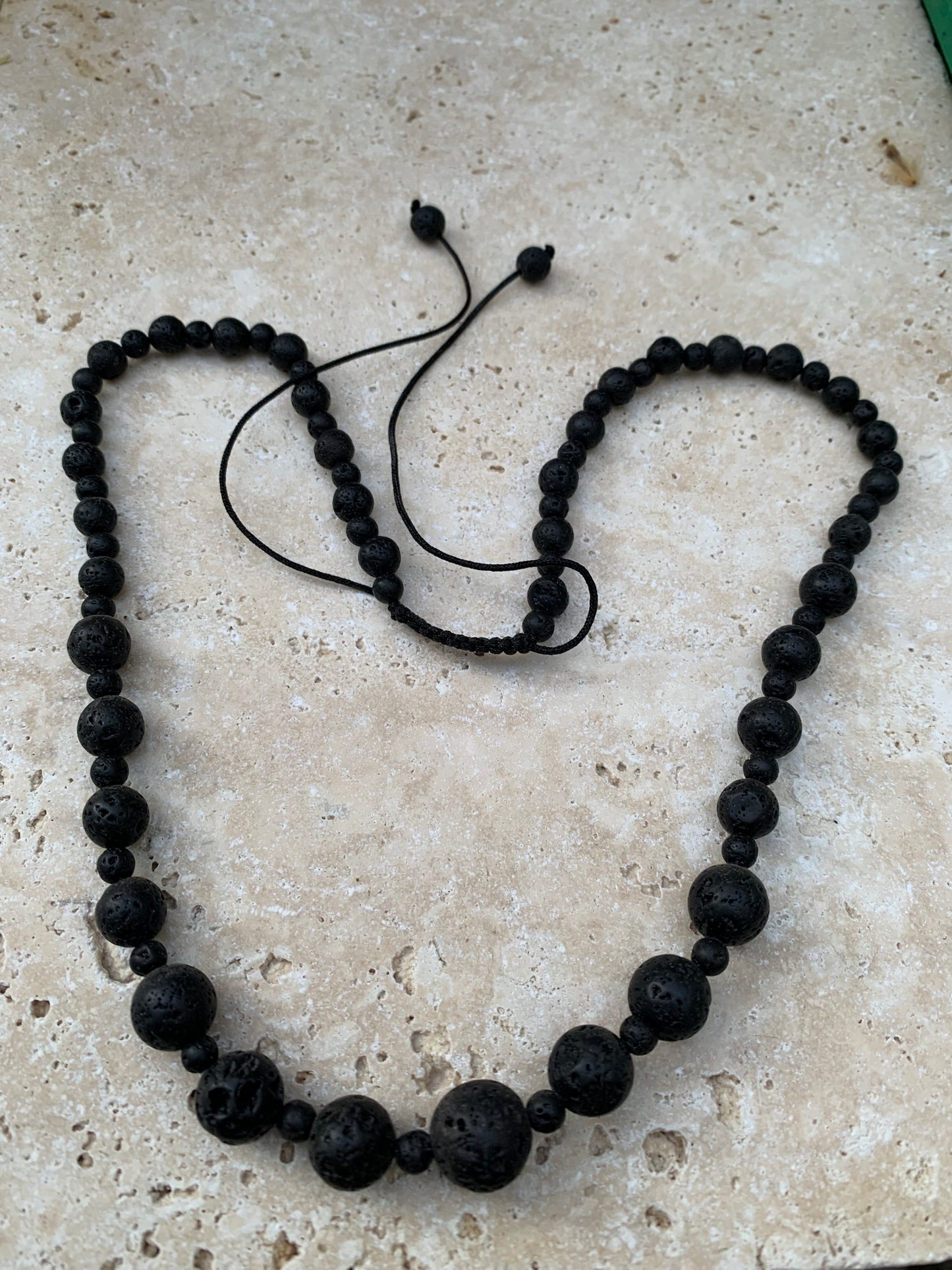 Pierre de lave, 'collier/ chute de perle', de forme ronde de 4 à 10 mm -50 cm. Fermeture coullissante. très belle pièce !