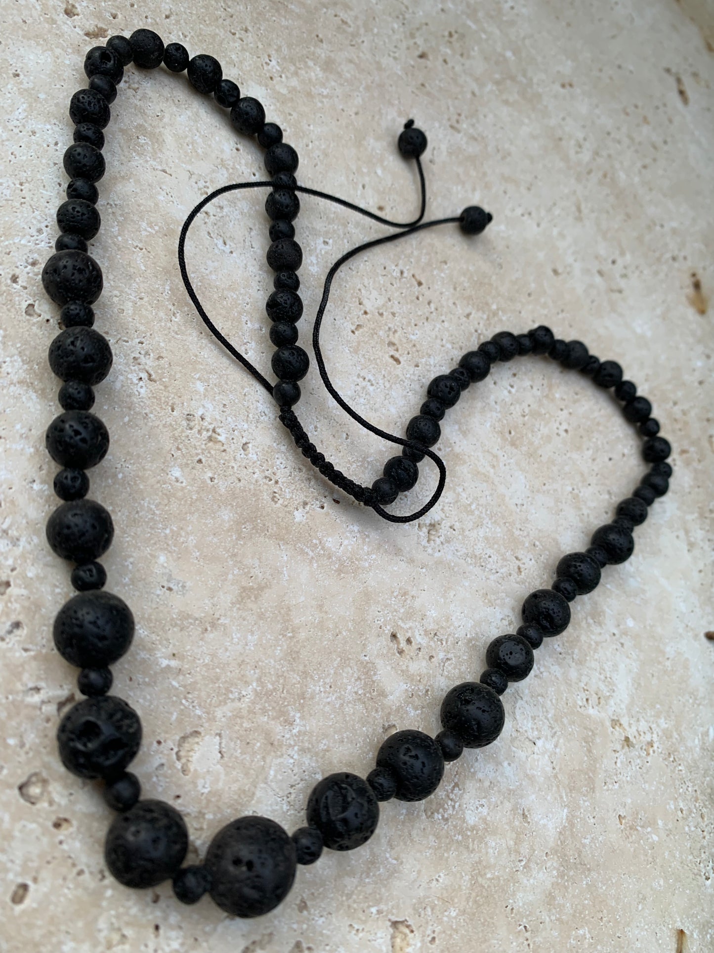 Pierre de lave, 'collier/ chute de perle', de forme ronde de 4 à 10 mm -50 cm. Fermeture coullissante. très belle pièce !
