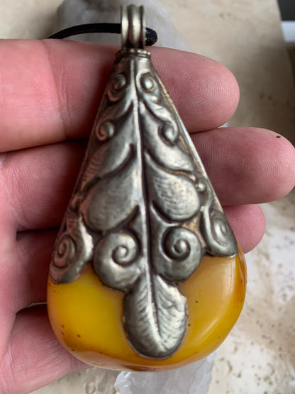 Pendentif en Copal (famille de l'Ambre), sertis en métal avec de majestueuses gravures. Impressionante pièce de 85 x 50 x 30 millimètres. Fait au Népal🇳🇵, un bijou ethnique unique et authentique (vendu avec cordon coulisant) !