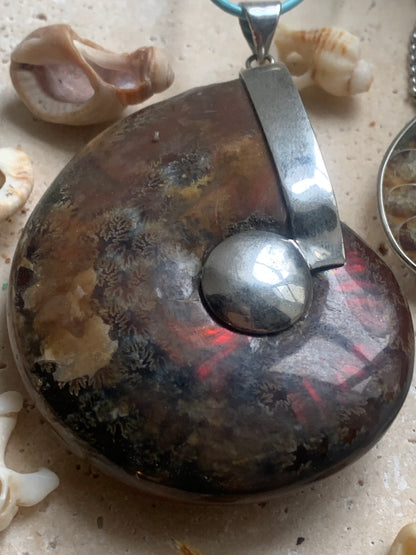 Fossil ammonite pendants, available in two sizes: 60x50x20 and 35x25x10 mm. Each piece is authentic and unique, revealing the natural spirals and fascinating patterns of this fossil. Comes with a drawstring, ready to wear or give as a gift!