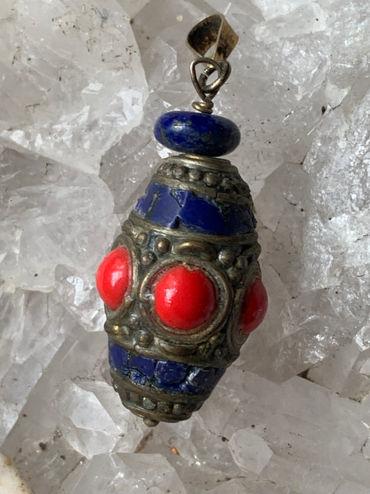 Lapis lazuli et corail, pendentif en métal argenté de type laiton, de 40 millimètres de hauteur x 15 de diamètre. Vendu avec cordon noir réglable offert !