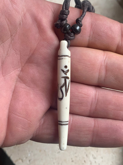 Elegant handcrafted pendant from Nepal, carved from bone with the sacred Om symbol, 60 millimeters high x 10 millimeters in diameter. Sold with a free adjustable black cord, perfect!