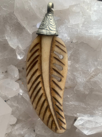 Handcrafted feather-shaped pendant from Nepal, carved from bone, measuring 70 millimeters high x 22 wide x 5 thick. Sold with a free adjustable black cord, perfect!