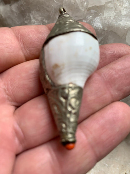 Handcrafted Nepalese shell pendant set in metal with beautiful engravings and a coral bead! 65 millimeters high x 28 mm in diameter. Sold with a free adjustable black cord, perfect!