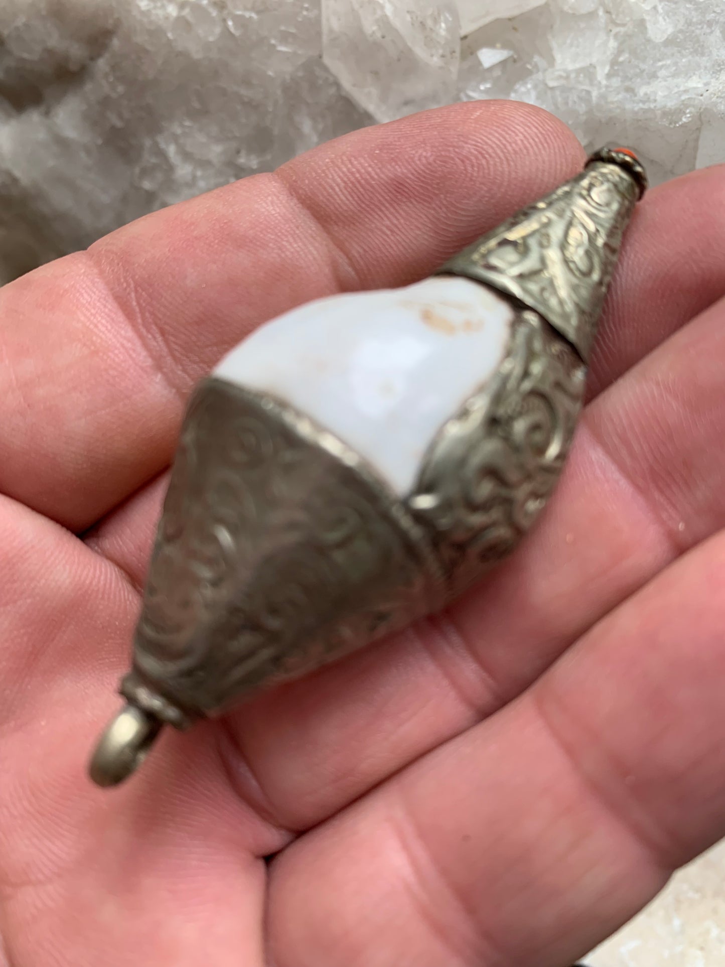 Handcrafted Nepalese shell pendant set in metal with beautiful engravings and a coral bead! 65 millimeters high x 28 mm in diameter. Sold with a free adjustable black cord, perfect!