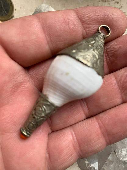 Handcrafted Nepalese shell pendant set in metal with beautiful engravings and a coral bead! 65 millimeters high x 28 mm in diameter. Sold with a free adjustable black cord, perfect!