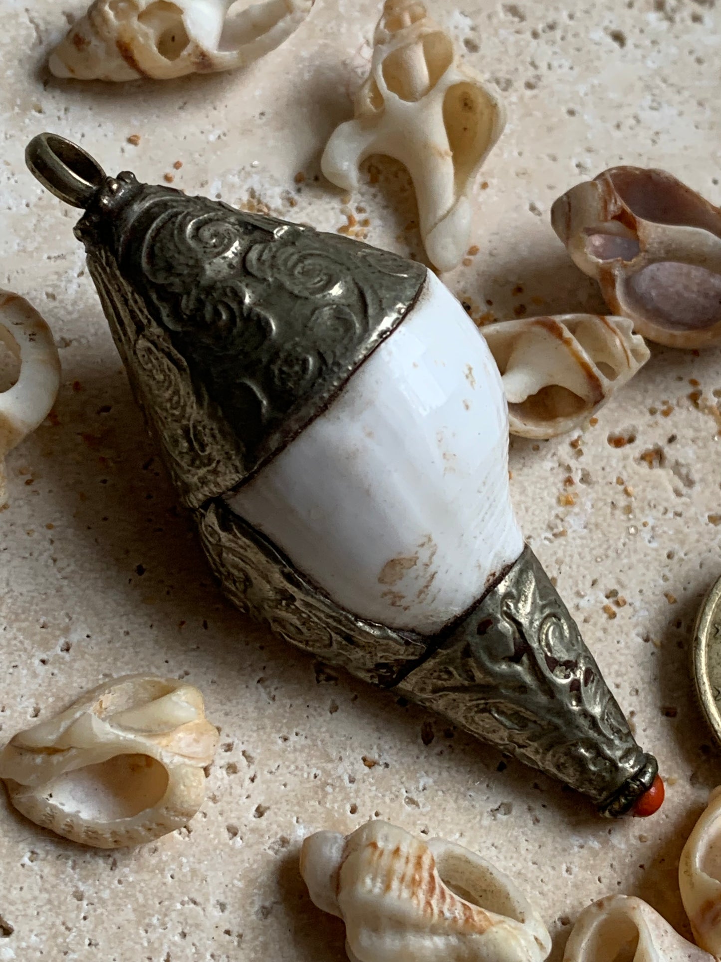 Handcrafted Nepalese shell pendant set in metal with beautiful engravings and a coral bead! 65 millimeters high x 28 mm in diameter. Sold with a free adjustable black cord, perfect!