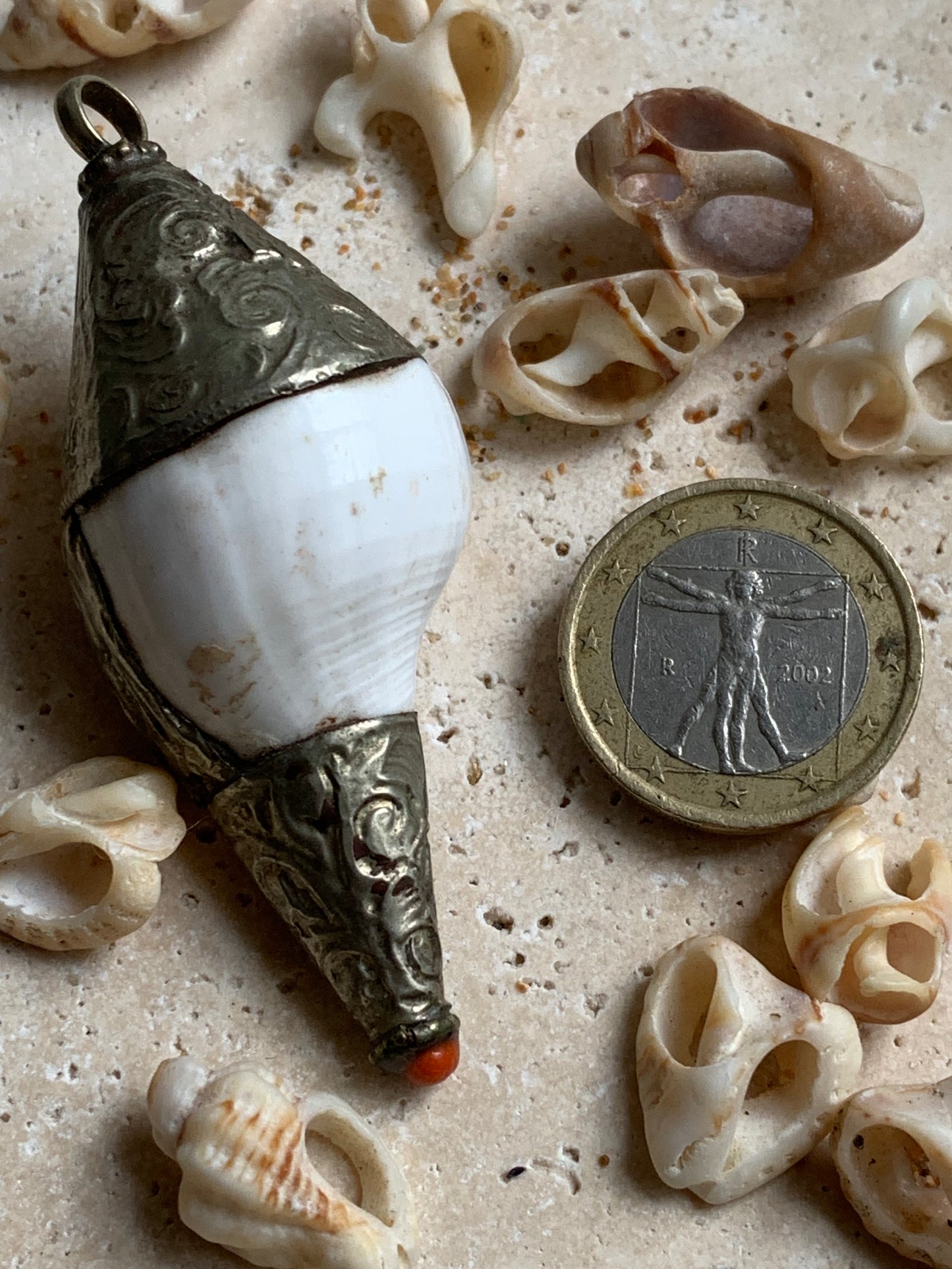 Handcrafted Nepalese shell pendant set in metal with beautiful engravings and a coral bead! 65 millimeters high x 28 mm in diameter. Sold with a free adjustable black cord, perfect!