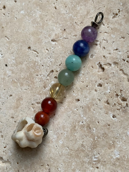 Pendentif '7 chakras' fait par Gem & Zen, au choix : 7 perles avec un coquillage naturel ou sans ! De 52 millimètres de hauteur x 6 millimètres de diamètre. Vendu avec cordon réglable de couleur noire !