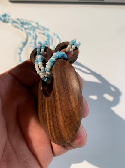 Collier/ Sautoir en perles avec pendentif en bois - ± 50 centimètres - Pendentif : ± 6 cm