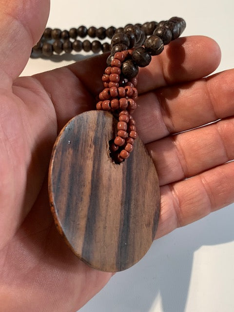 Collier/ Sautoir en perles avec pendentif en bois et nacre - ± 50 centimètres - Pendentif : ± 6 cm