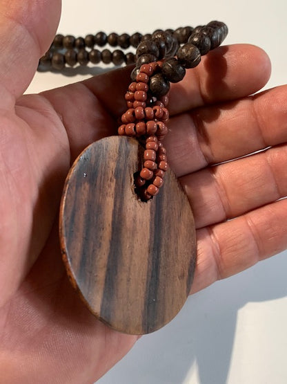 Collier/ Sautoir en perles avec pendentif en bois et nacre - ± 50 centimètres - Pendentif : ± 6 cm