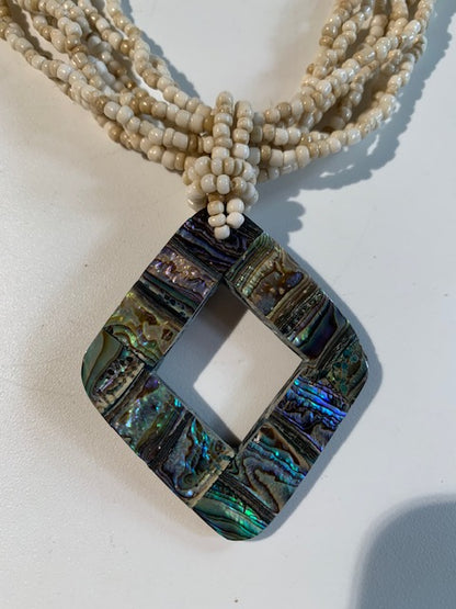 Collier/ Sautoir en perles avec pendentif en nacre - ± 50 centimètres - Pendentif : ± 5,5 x 5 cm