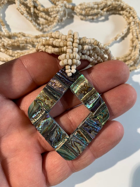 Collier/ Sautoir en perles avec pendentif en nacre - ± 50 centimètres - Pendentif : ± 5,5 x 5 cm