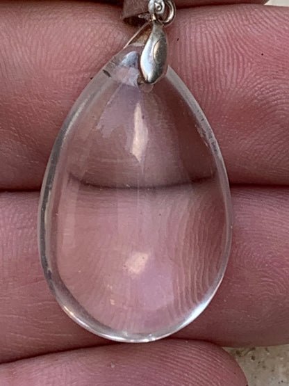 Cristal de roche/ quartz, pendentif 'goutte' en Argent de qualité AAA, 40mm de hauteur x 20 de largeur x 9 d'épaisseur. Vendu avec cordon réglable de couleur noire ! Un bijou en cristal, pour ceux qui aiment marcher entre lumière et mystère !