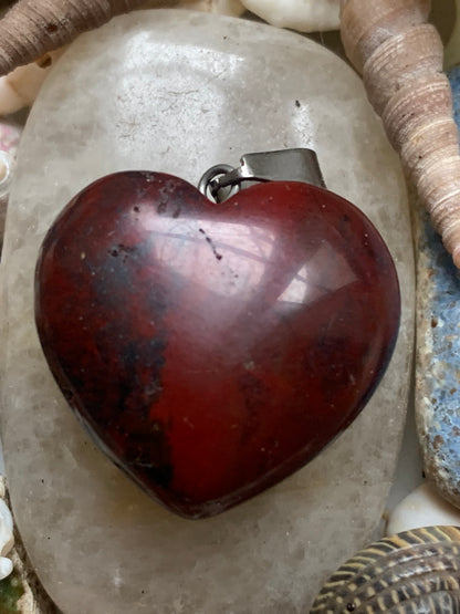 Jaspe rouge, pendentif 'Coeur' en Argent, de 32 millimètres de hauteur x 25 millimètres de largeur x 11 d'épaisseur. Vendu avec un cordon réglable de couleur noire !