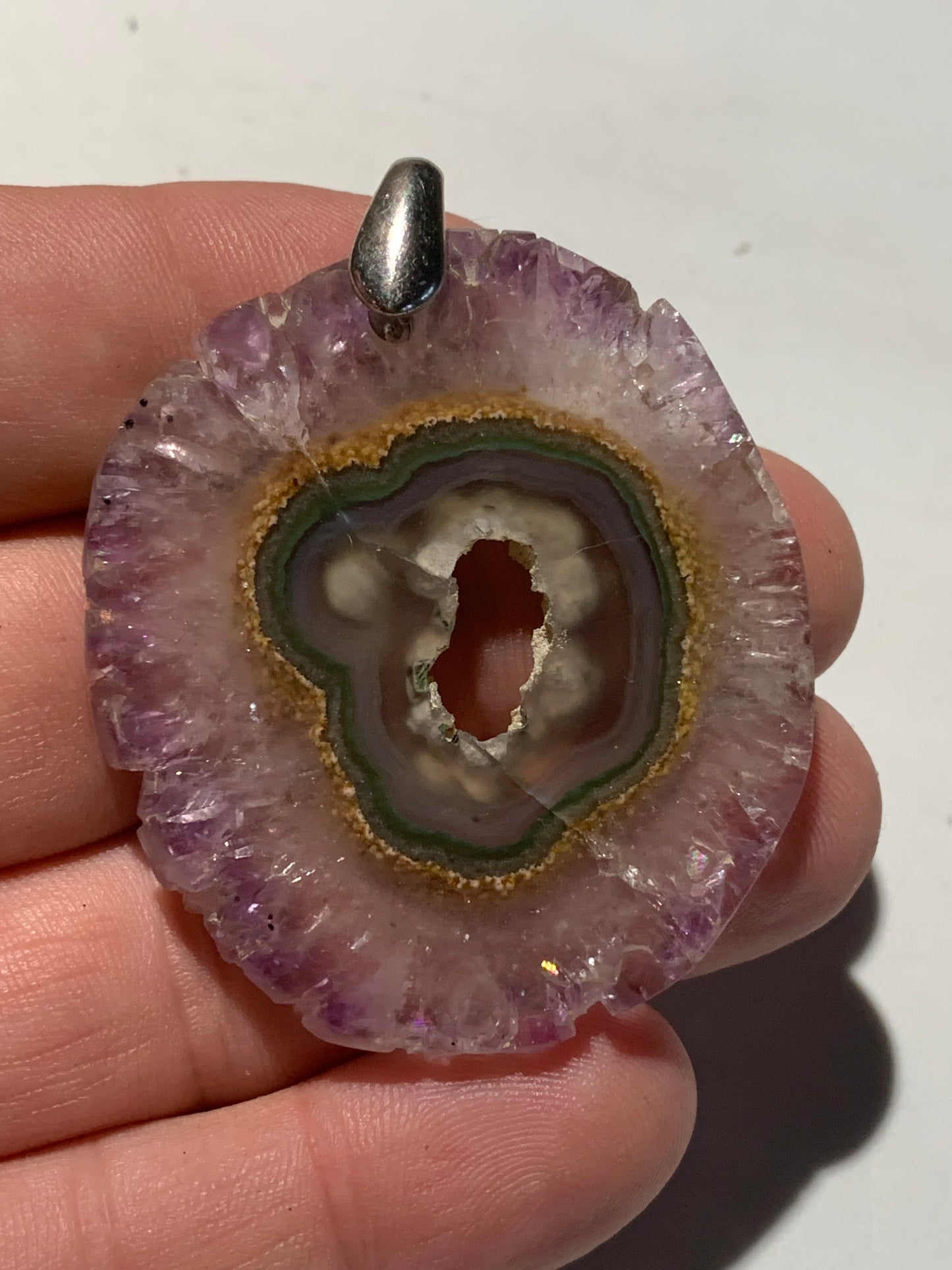 Améthyste, pendentif en 'tranche' de 57 mm de hauteur x 46 de largeur x 6 d'épaisseur. Vendu avec cordon réglable de couleur noire offert !