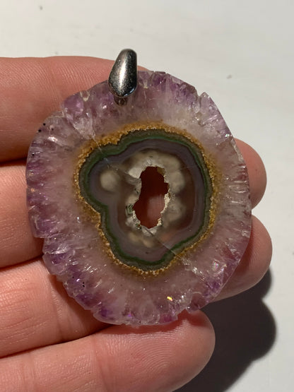 Améthyste, pendentif en 'tranche' de 57 mm de hauteur x 46 de largeur x 6 d'épaisseur. Vendu avec cordon réglable de couleur noire offert !