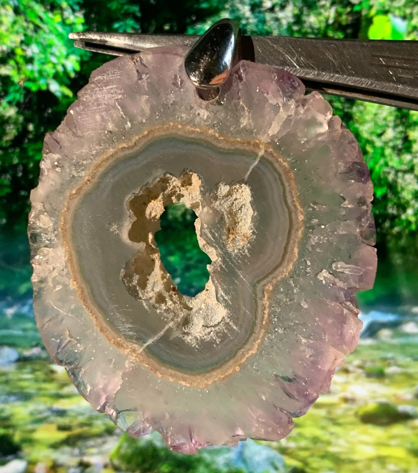 Améthyste, pendentif en 'tranche' de 57 mm de hauteur x 46 de largeur x 6 d'épaisseur. Vendu avec cordon réglable de couleur noire offert !