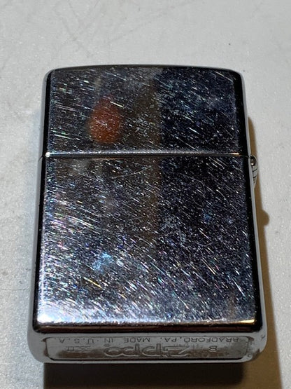 Briquet Zippo (B – XII), métal argenté, avec cabochon en tourmaline collé. Dimensions : 5 × 4 × 1 cm. Poids : 58,5 g.