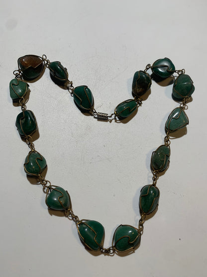 Collier artisanal en aventurine verte naturelle, composé de pierres polies de forme libre, montées à la main avec un fil métallique doré. Fermoir à vis. Style bohème et lithothérapie. Très bel effet porté.