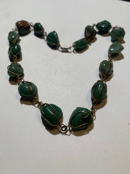 Collier artisanal en aventurine verte naturelle, composé de pierres polies de forme libre, montées à la main avec un fil métallique doré. Fermoir à vis. Style bohème et lithothérapie. Très bel effet porté.