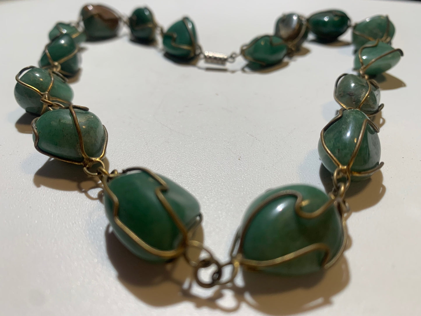 Collier artisanal en aventurine verte naturelle, composé de pierres polies de forme libre, montées à la main avec un fil métallique doré. Fermoir à vis. Style bohème et lithothérapie. Très bel effet porté.