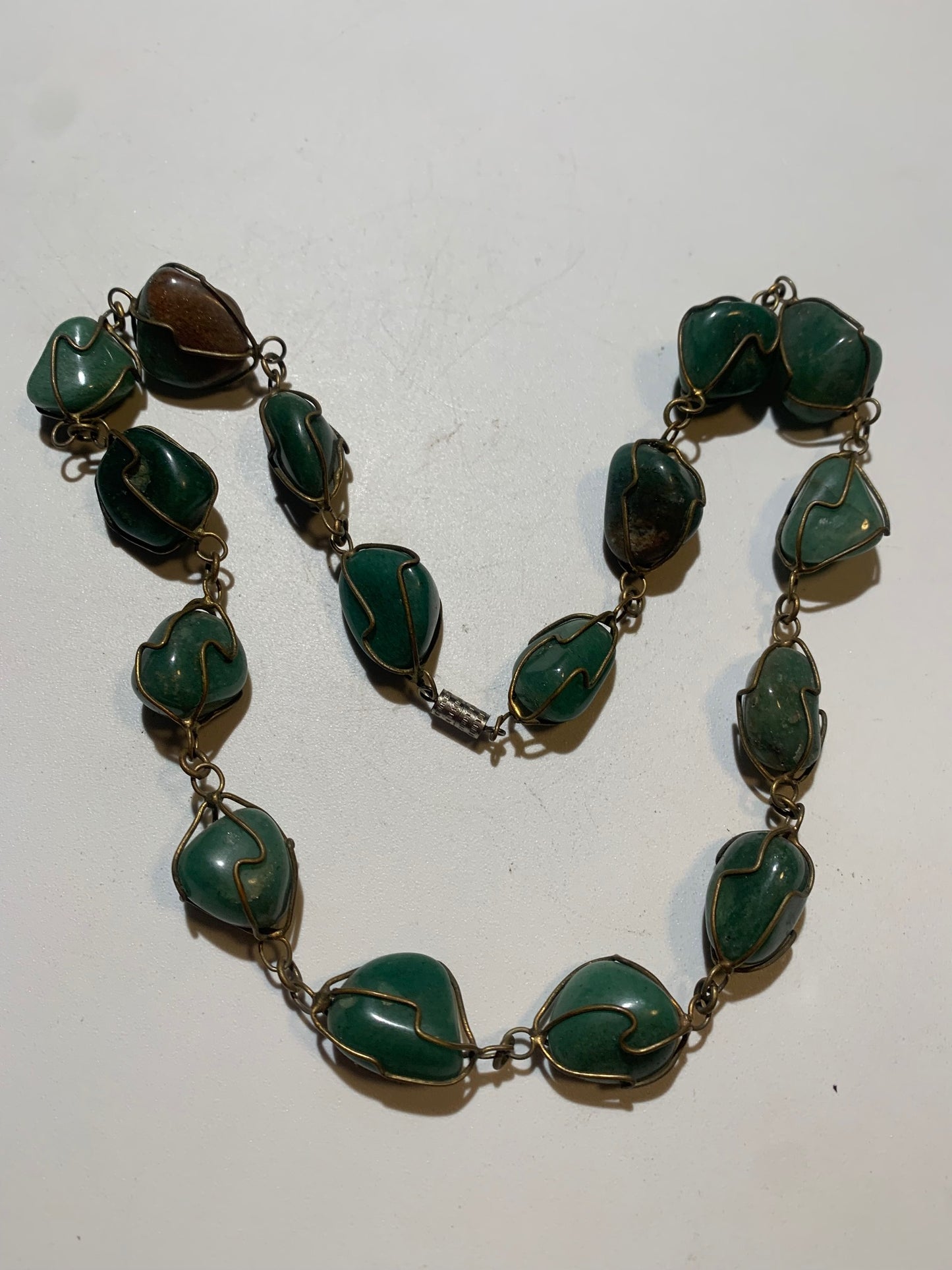 Collier artisanal en aventurine verte naturelle, composé de pierres polies de forme libre, montées à la main avec un fil métallique doré. Fermoir à vis. Style bohème et lithothérapie. Très bel effet porté.