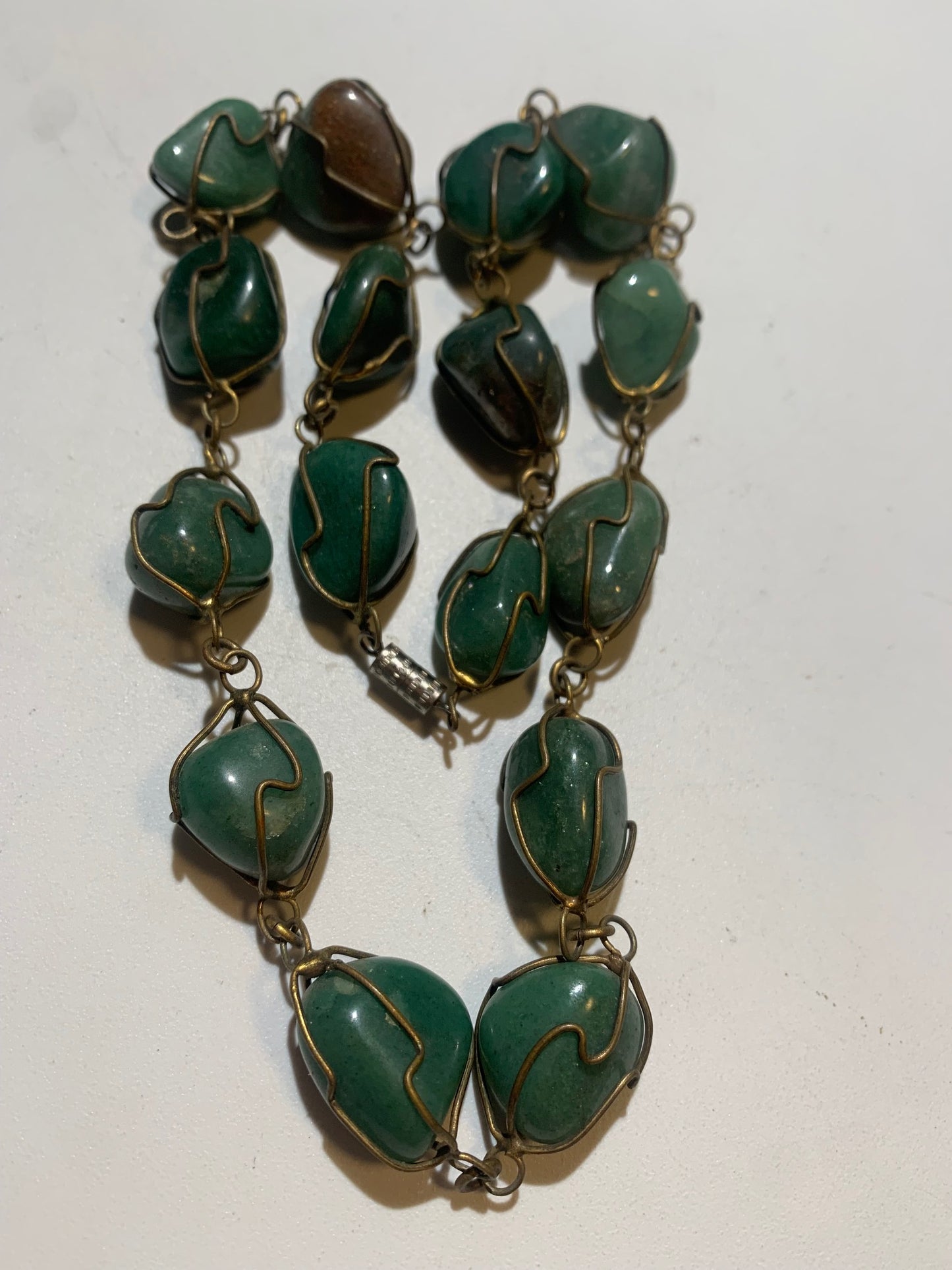 Collier artisanal en aventurine verte naturelle, composé de pierres polies de forme libre, montées à la main avec un fil métallique doré. Fermoir à vis. Style bohème et lithothérapie. Très bel effet porté.