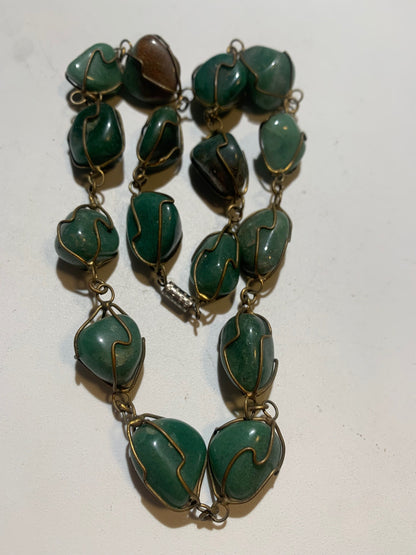 Collier artisanal en aventurine verte naturelle, composé de pierres polies de forme libre, montées à la main avec un fil métallique doré. Fermoir à vis. Style bohème et lithothérapie. Très bel effet porté.
