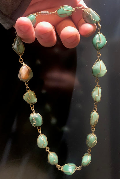 Collier artisanal en aventurine verte naturelle, composé de pierres polies de forme libre, montées à la main avec un fil métallique doré. Fermoir à vis. Style bohème et lithothérapie. Très bel effet porté.