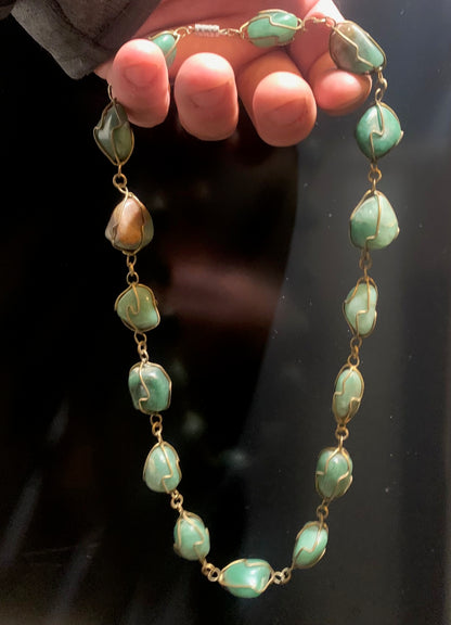 Collier artisanal en aventurine verte naturelle, composé de pierres polies de forme libre, montées à la main avec un fil métallique doré. Fermoir à vis. Style bohème et lithothérapie. Très bel effet porté.