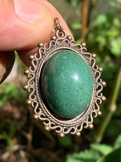 Médaillon couleur Bronze avec Aventurine/ quartz vert, de 36 mm de ht x30 x3. Vendu avec un cordon noir réglable !