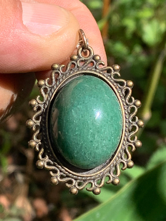 Médaillon couleur Bronze avec Aventurine/ quartz vert, de 36 mm de ht x30 x3. Vendu avec un cordon noir réglable !