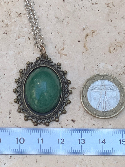 Médaillon couleur Bronze avec Aventurine/ quartz vert, de 36 mm de ht x30 x3. Vendu avec un cordon noir réglable !