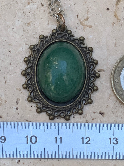 Médaillon couleur Bronze avec Aventurine/ quartz vert, de 36 mm de ht x30 x3. Vendu avec un cordon noir réglable !